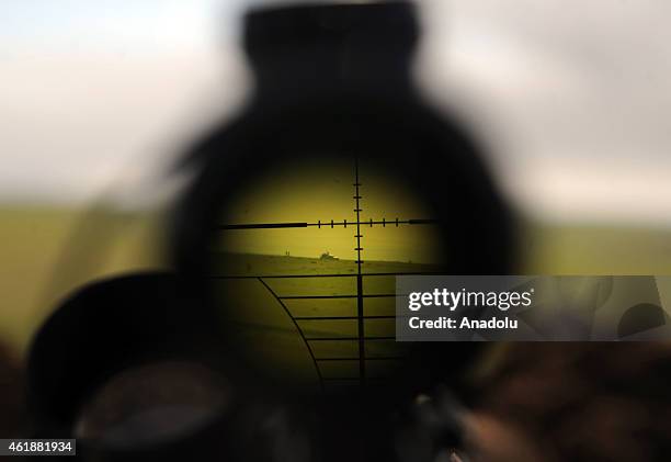 Militants are seen through binoculars of a rifle during clashes between Islamic State of Iraq and the Levant militants and Peshmerga in Mawara town...