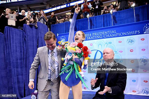 Gracie Gold, with her coaches Scott Brown and Frank Carroll, celebrates in the kiss and cry after skating in the ladies free skate during the...