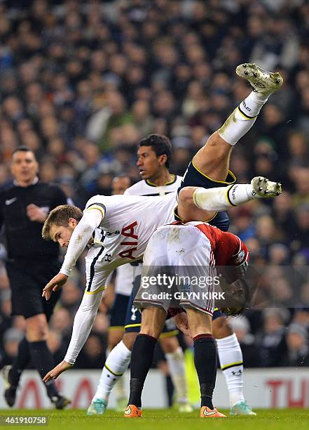 Tottenham Hotspur's English defender Eric Dier falls over Sheffield United's Scottish striker Marc McNulty during the English League Cup semi-final...