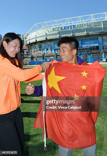 Ying Ying Duan of China helps Di Wu pose with the national flag in front of Rod Laver Arena ahead of the 2014 Australian Open at Melbourne Park on...