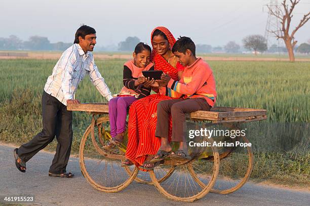 indian woman sharing tablet device with children - uttar pradesh stock pictures, royalty-free photos & images