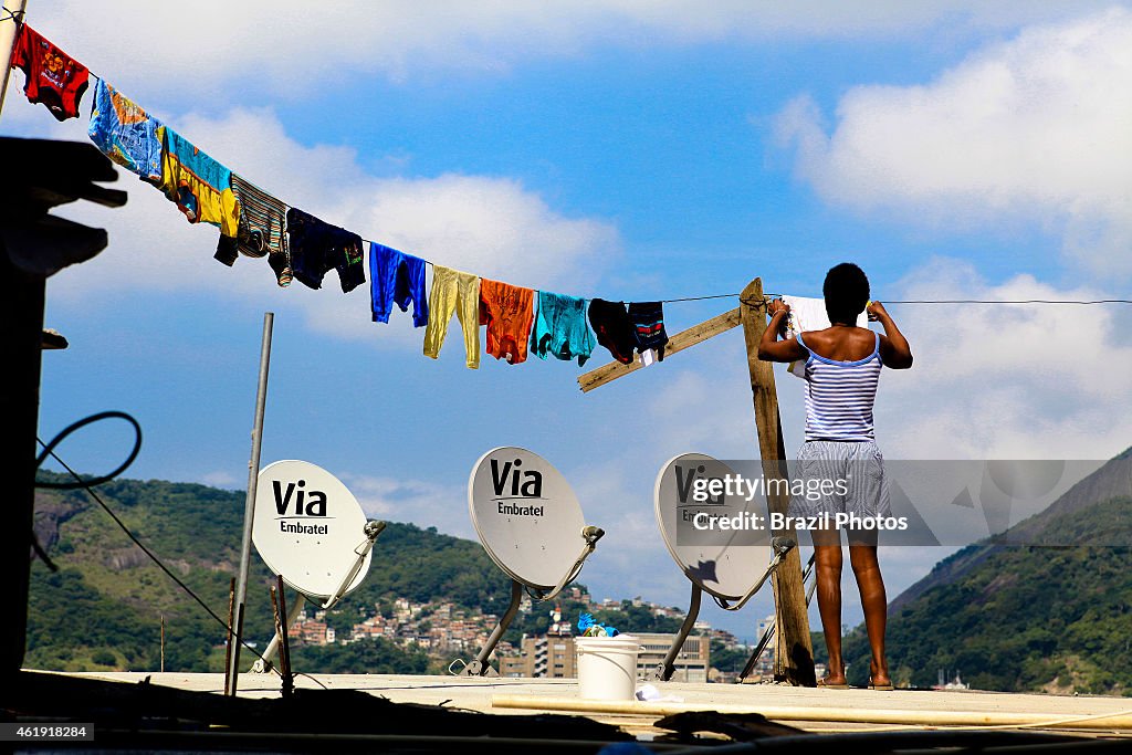 Woman hanging clothes on her house slab-cover at top of...