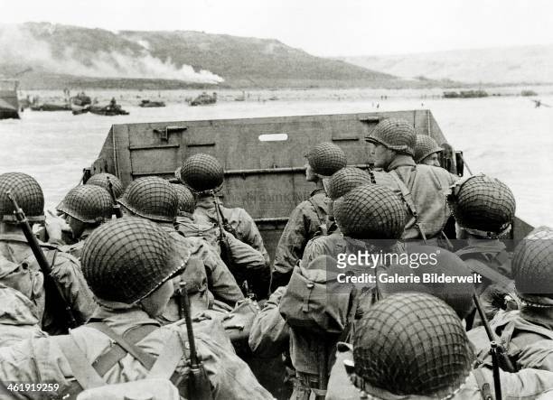 Soldiers watch the Normandy coast from a Landing Craft Vehicle, Personnel heading towards Omaha Beach Easy Red sector. 6th June 1944. Several...
