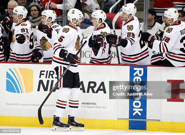 David Rundblad of the Chicago Blackhawks celebrates his first period goal with teammates in the first period during the game at Consol Energy Center...