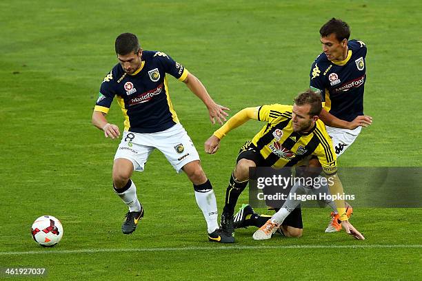 Nick Montgomery and Trent Sainsbury of the Mariners tackle Jeremy Brockie of the Phoenix during the round 14 A-League match between the Wellington...