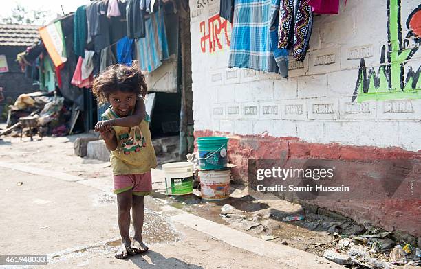 Young girl plays in the Kapali Bagan slum on December 10, 2013 in Kolkata, India. Almost one third of the Kolkata population live in slums and a...