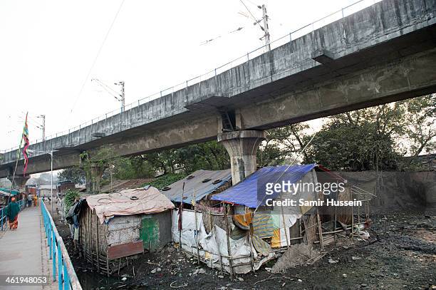 Houses are seen built in a slum under a railway track on December 11, 2013 in Kolkata, India. Almost one third of the Kolkata population live in...