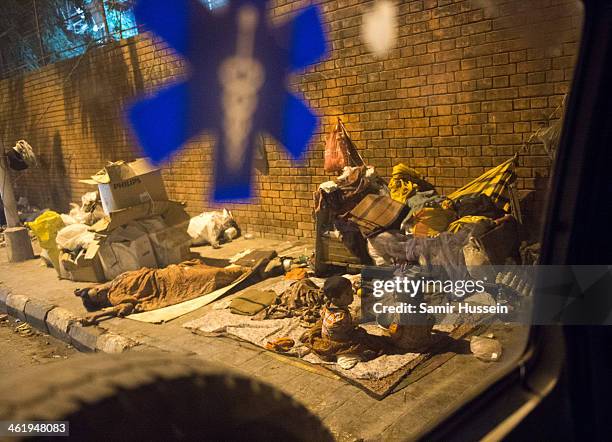 People are seen sleeping on the street from the back of an ambulance on December 11, 2013 in Kolkata, India. Almost one third of the Kolkata...