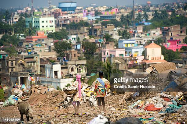 Girls search through a rubbish tip by the Kapali Bagan slum for useful artifacts to sell on December 10, 2013 in Kolkata, India. Almost one third of...