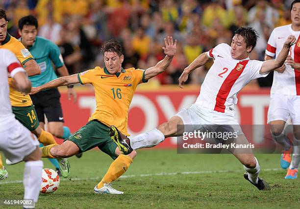 Nathan Burns of Australia attempts to get a kick away as he is pressured by the defence of Ren Hang of China during the 2015 Asian Cup match between...