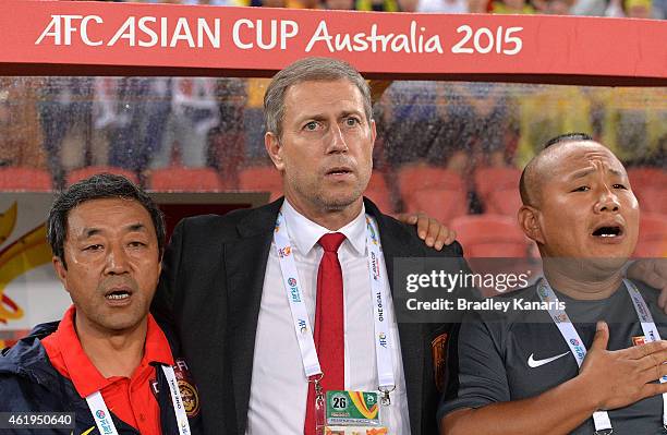 Coach of China Alain Perrin embraces his coaching staff members for the national anthem of China before the 2015 Asian Cup match between China PR and...