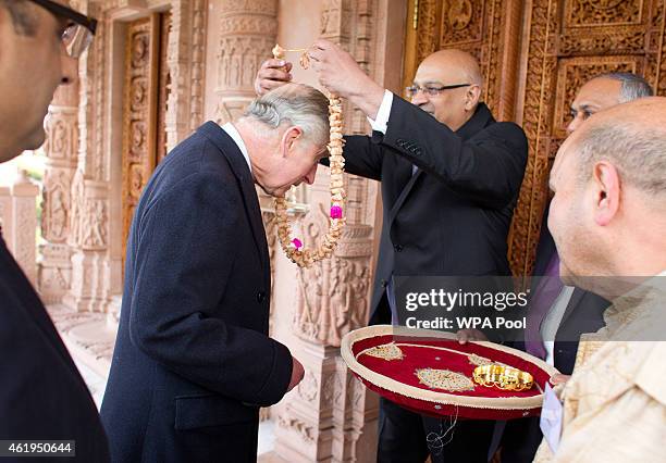 Prince Charles, Prince Of Wales is anointed on the forehead and given a sandal wood garland before a tour of the Jain Temple on January 22, 2015 in...