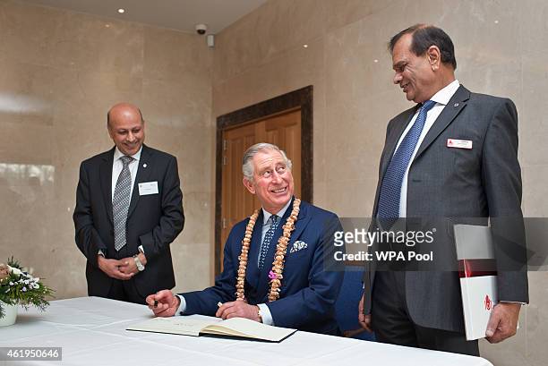 Prince Charles, Prince Of Wales signs the visitors book toward the end of a tour of the Jain Temple on January 22, 2015 in Potters Bar,...