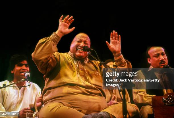 Pakistani musician Nusrat Fateh Ali Khan sings Qawwali devotional Sufi music with his group, Party, at a World Music Institute concert at Town Hall,...