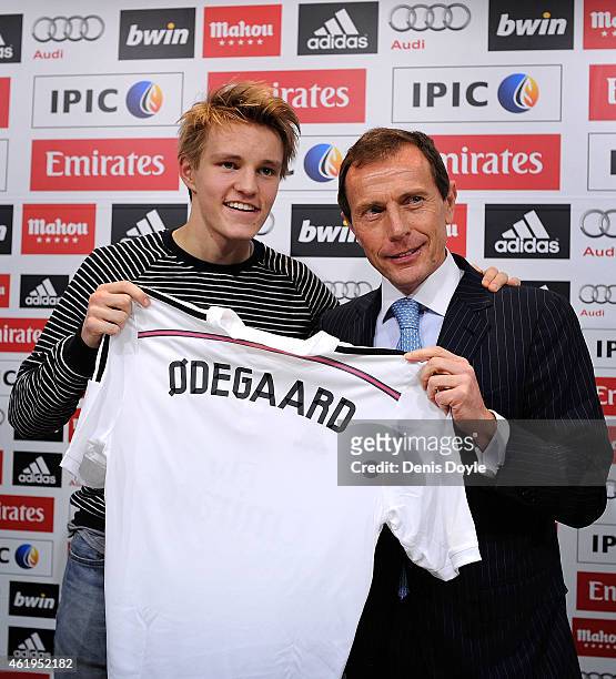 Martin Odegaard from Norway holds his new Real Madrid shirt with former Real player Emilio Butragueno during a press conference at Real Madrid's...