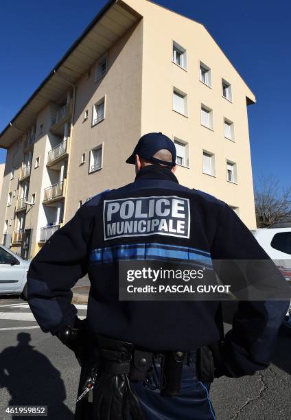 Municipal police officer stands January 22, 2015 in front of a building in Beziers, southern France, where a Russian Chechen suspected of preparing a...