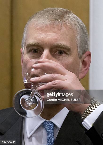 Britain's Prince Andrew drinks water during a reception with business leaders on the sidelines of the World Economic Forum in Davos on January 22,...