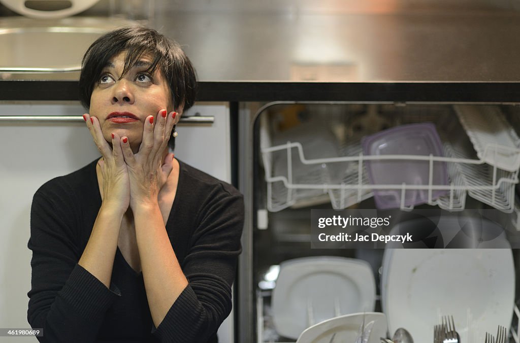 Distressed housewife next to open dishwasher
