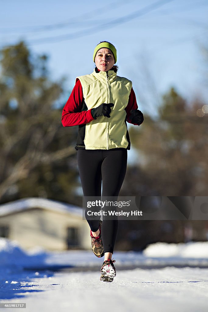 Woman jogging on snowy street