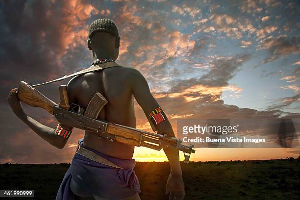 young karo tribe man with semi-automatic rifle - machinegeweer stockfoto's en -beelden