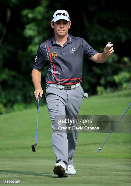 Louis Oosthuizen of South Africa waves to the crowd on the 17th green after making a tap-in birdie during the final round of the 2014 Volvo Golf...