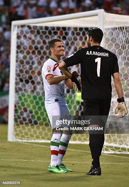 Iran's Vorya Ghafouri speaks with goalkeeper Alireza Haghighi during the Asian Cup quarter-final football match between Iraq and Iran in Canberra on...
