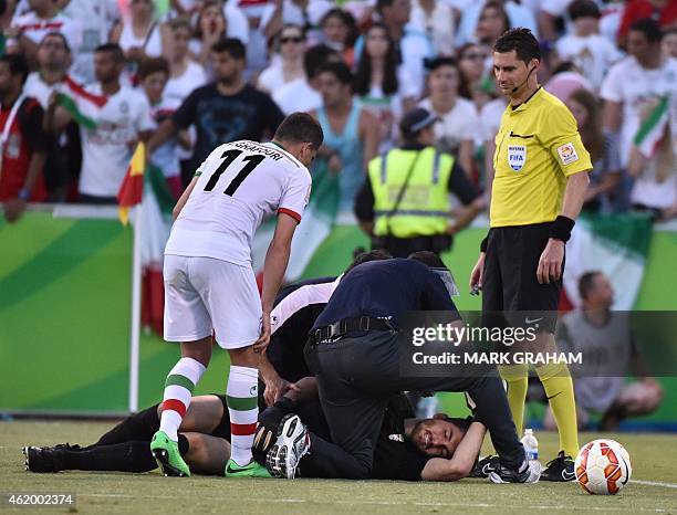 Vorya Ghafouri of Iran looks at goalkeeper Alireza Haghighi of Iran after being knocked down during the Asian Cup quarter-final football match...