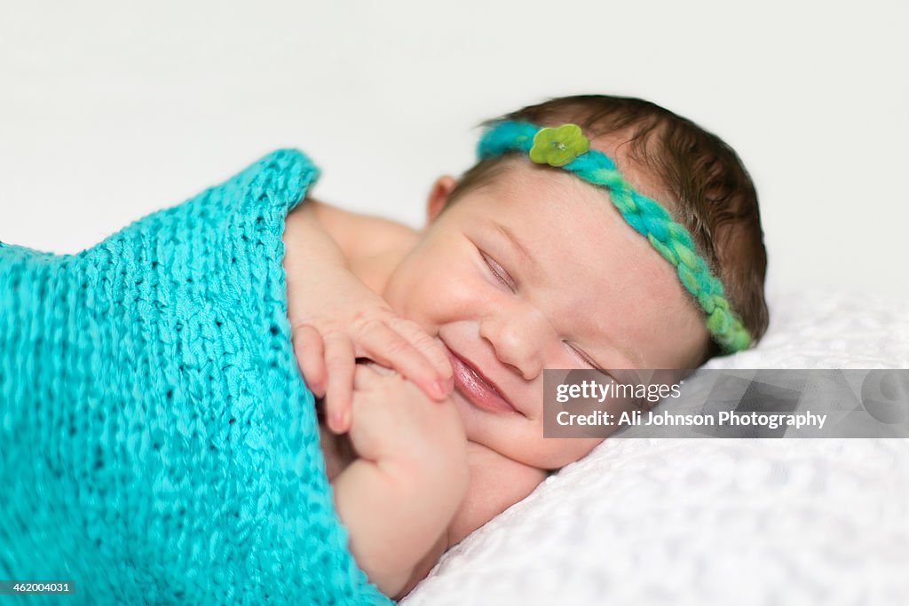 A newborn baby girl smiles