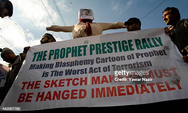 Kashmiri Muslims hold an effigy of Stephane Charbonnier, the editor of Charlie Hebdo who was killed in the attacks in Paris, during a protest against...