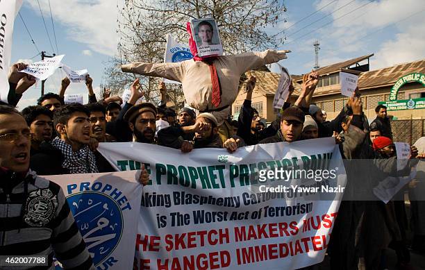 Kashmiri Muslims hold an effigy of Stephane Charbonnier, the editor of Charlie Hebdo who was killed in the attacks in Paris, during a protest against...