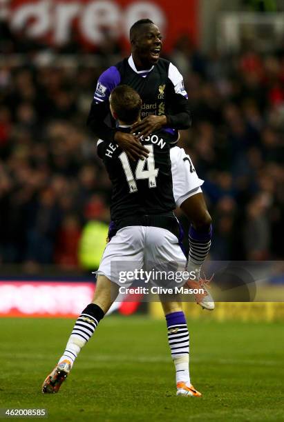 Aly Cissokho of Liverpool celebrates with Jordan Henderson , as his shot deflects in off Ryan Shawcross of Stoke City for an own goal for their first...