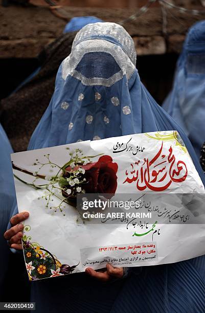 An Afghan demonstrator holds a poster reading, "My life, Muhammad" during a protest against the printing of satirical sketches of the Prophet...