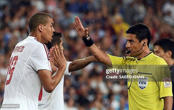 Ismail Ahmed of the United Arab Emirates talks with match referee Alireza Faghani of Iran during the quarter-final football match between Japan and...