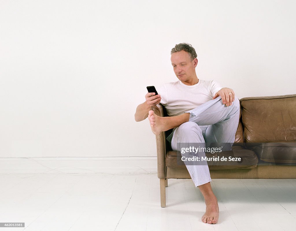 Man with smartphone on sofa