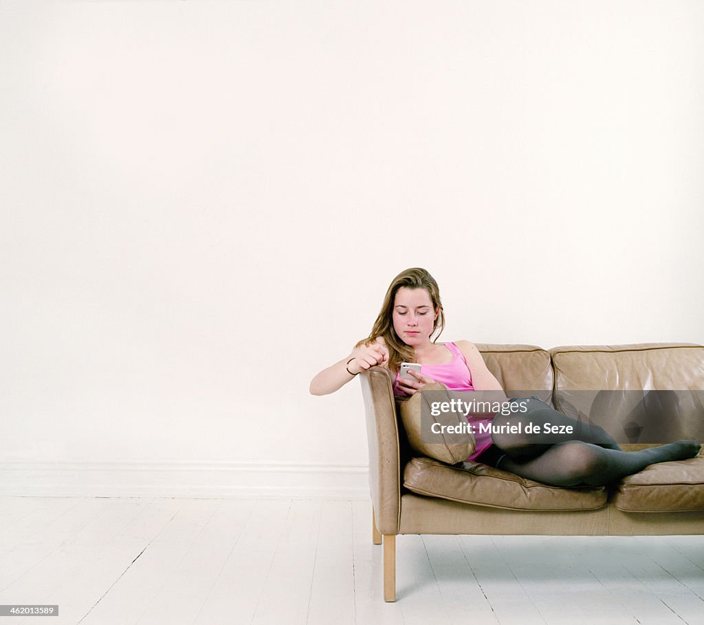 Girl with smartphone on sofa