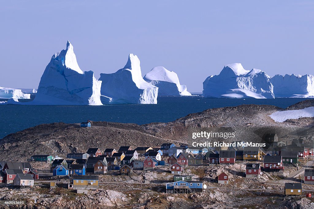 Icebergs over looking houses