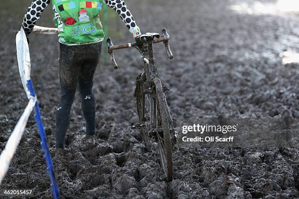 Rider pushes his bike through a muddy section of course after competing in the 2014 National Cyclo-Cross Championships at Moorways Leisure Centre on...