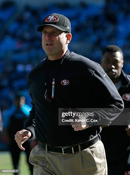 Head coach Jim Harbaugh of the San Francisco 49ers runs on the field during warm ups prior to the NFC Divisional Playoff Game against the Carolina...