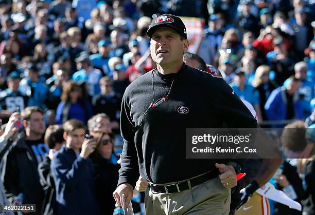 Head coach Jim Harbaugh of the San Francisco 49ers runs onto the field before the NFC Divisional Playoff Game against the Carolina Panthers at Bank...