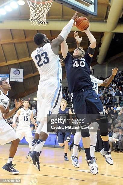 Matt Stainbrook of the Xavier Musketeers trys to take a shot over Daniel Ochefu of the Villanova Wildcats during a college basketball game at The...