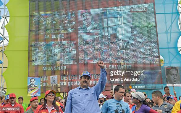 Venezuelan President Nicolas Maduro with his fist up in the air next to First Lady Cilia Flores and Vice President Jorge Arreaza during the "March of...