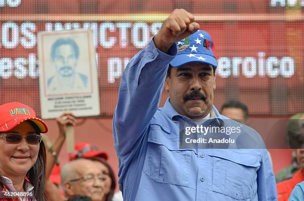Venezuelan President Nicolas Maduro with his fist up in the air next to First Lady Cilia Flores during the "March of the Undefeated" commemorating...