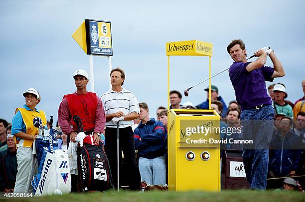 Nick Faldo of England plays his tee shot at the par 4, 15th hole watched by his caddie Fanny Sunesson of Sweden and his playing partner John Cook of...