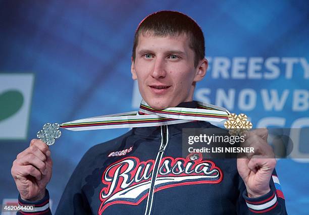 First placed Russia's Andrey Sobolev celebrates on the podium after he received his gold medal for the Men's Snowboard Parallel Giant Slalom and the...