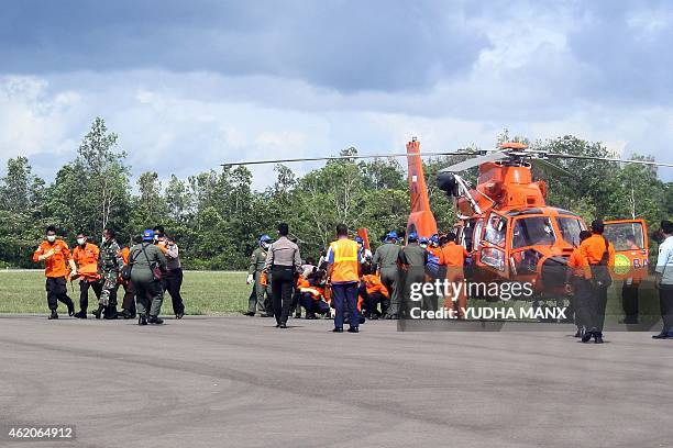 Indonesian rescue personnel unload bags containing bodies, recovered from the underwater wreckage of ill-fated AirAsia flight QZ8501, from a search...