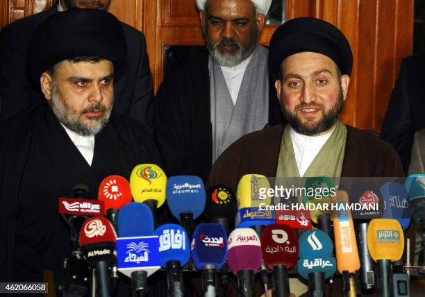 Iraqi Shiite cleric Moqtada al-Sadr and Iraqi Shiite Muslim leader Ammar al-Hakim speak during a meeting to discuss economic and security issues held...