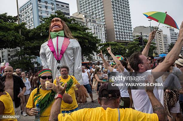 Revelers dance next to a giant doll during the performance of Bloco da Ansiedade, a carnival group, on a street in Rio de Janeiro, Brazil on January...