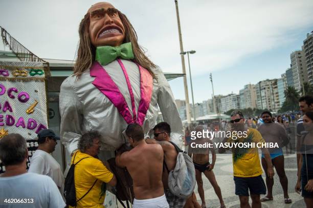 Giant doll is prepared during the performance of Bloco da Ansiedade, a carnival group, on a street in Rio de Janeiro, Brazil on January 12, 2014. AFP...