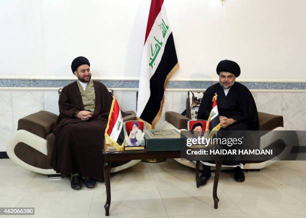 Iraqi Shiite cleric Moqtada al-Sadr and Iraqi Shiite Muslim leader Ammar al-Hakim sit during a meeting to discuss economic and security issues held...