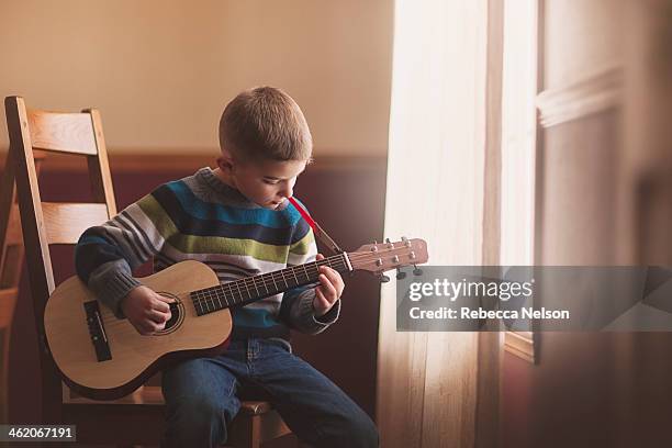 boy and his guitar - kids instruments fotografías e imágenes de stock